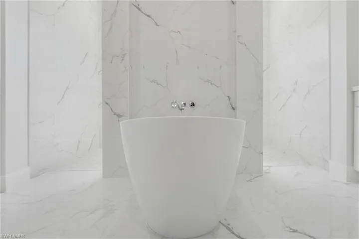 Bathroom featuring tile patterned floors and tile walls