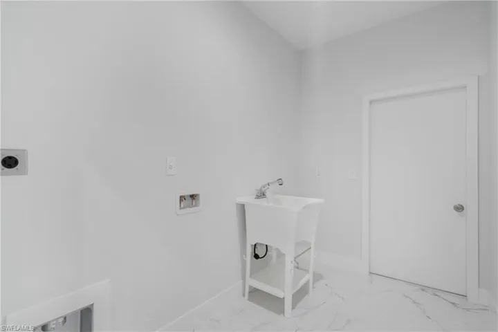 Washroom featuring electric dryer hookup, tile patterned flooring, and hookup for a washing machine
