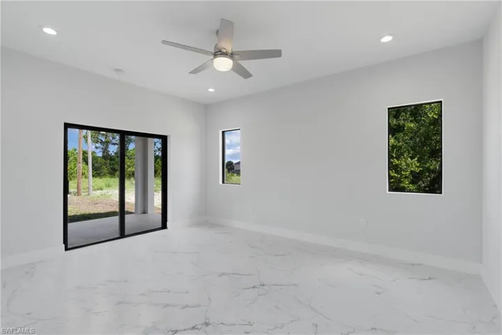 Unfurnished room with a wealth of natural light and ceiling fan