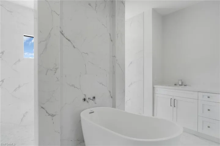 Bathroom featuring vanity, tile patterned floors, and tile walls