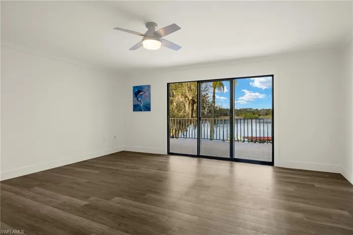 Spare room featuring ornamental molding, dark hardwood / wood-style floors, ceiling fan, and a water view