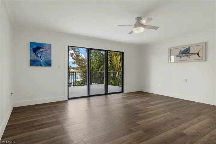 Spare room featuring ornamental molding, dark wood-type flooring, and ceiling fan