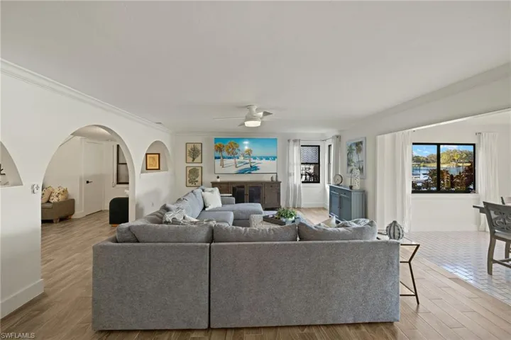 Living room featuring crown molding, light hardwood / wood-style floors, and ceiling fan