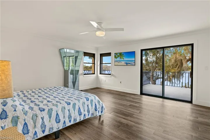 Bedroom featuring crown molding, ceiling fan, dark wood-type flooring, and access to outside