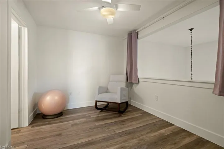 Living area with ceiling fan and wood-type flooring