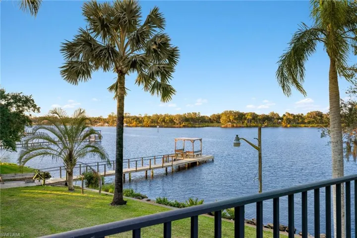 Dock area with a lawn and a water view