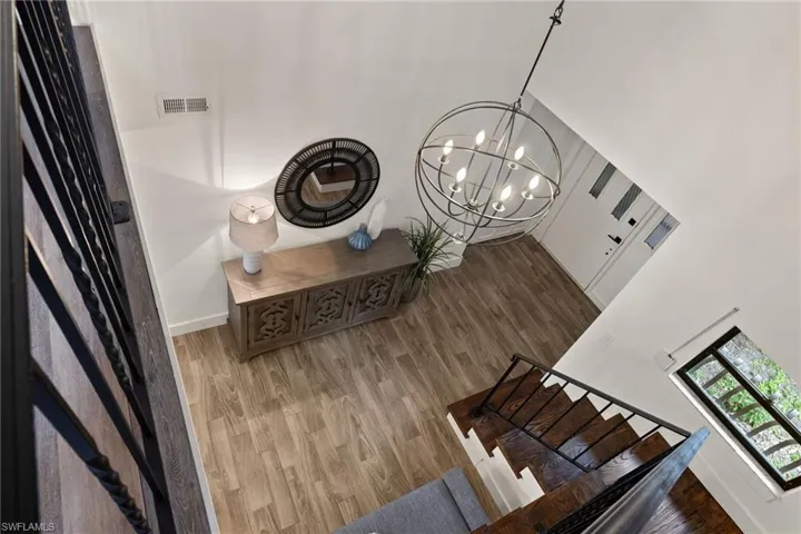 Stairway with a chandelier and hardwood / wood-style floors