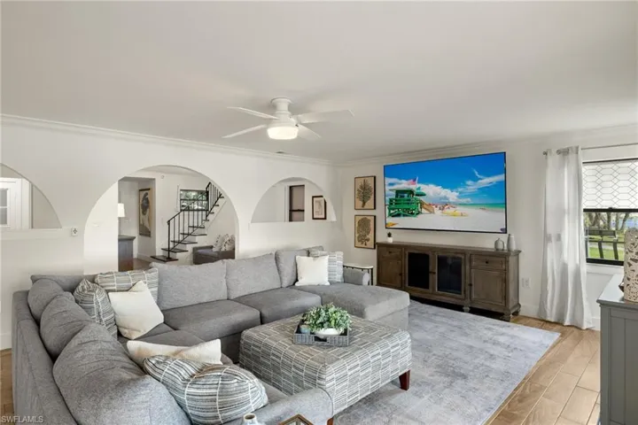 Living room featuring ornamental molding, ceiling fan, and light hardwood / wood-style floors