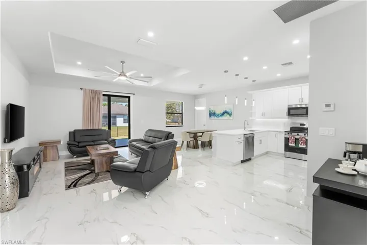 Open-concept living space featuring high ceilings, recessed lighting, and large format polished tile flooring
