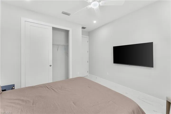 Recessed lighting, ceiling fan, and light-toned flooring