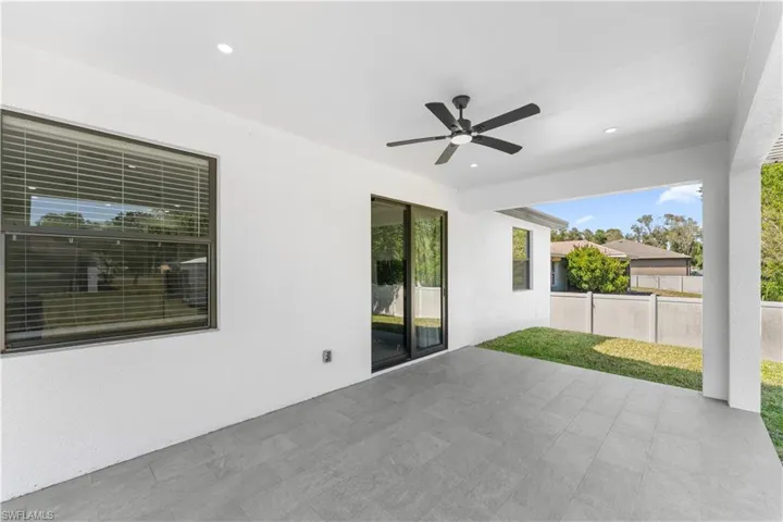 Covered patio featuring recessed lighting and a ceiling fan, grey-toned tile flooring, and a sliding glass door