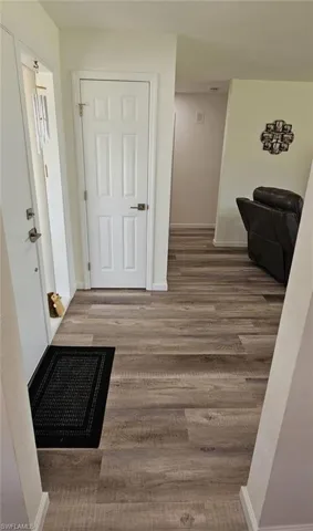 Corridor featuring baseboards and wood finished floors