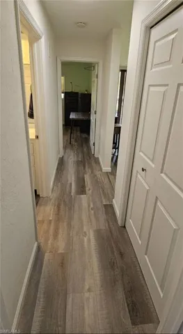 Corridor featuring baseboards and wood finished floors