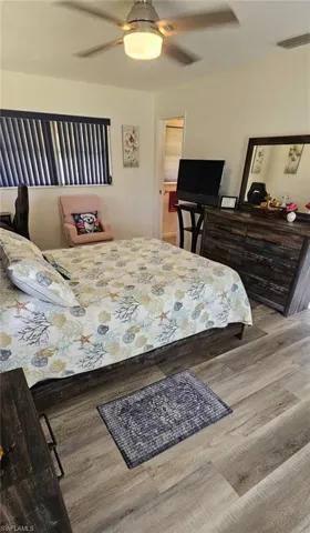 Bedroom with visible vents, wood finished floors, and ceiling fan