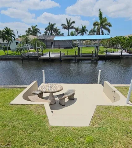 View of dock featuring a yard and a water view