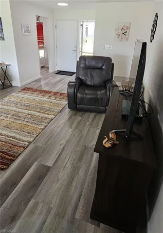 Living area with baseboards and wood finished floors