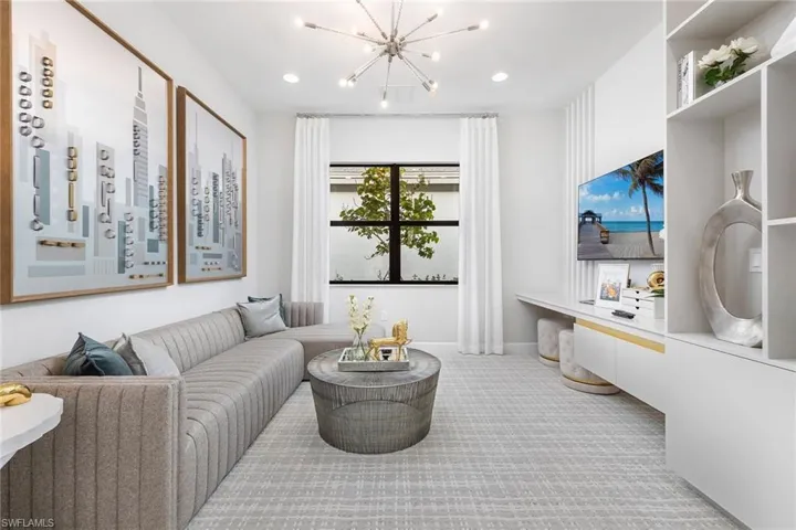 Carpeted living room with a chandelier, baseboards, and recessed lighting