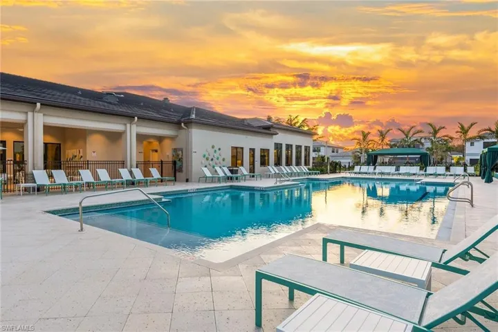 Pool at dusk featuring a community pool, fence, and a patio