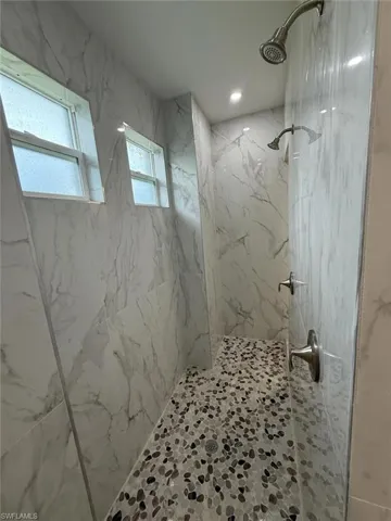 Bathroom featuring a marble finish shower