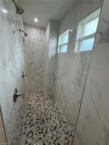 Bathroom featuring a marble finish shower