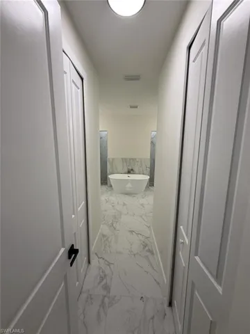Corridor with light marble finish flooring and baseboards