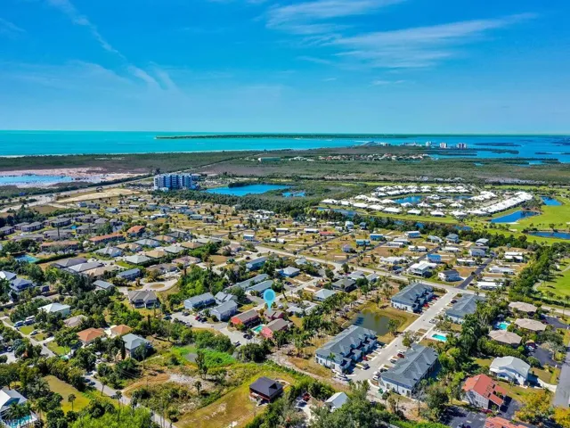 Aerial perspective of suburban area featuring a nearby body of water