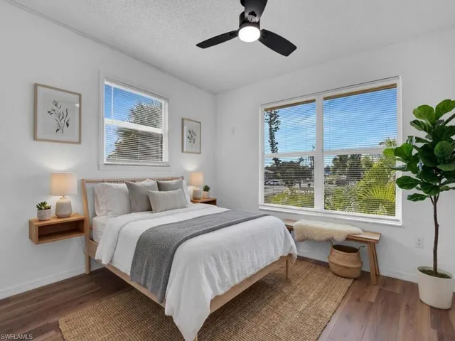 Bedroom with dark wood-style floors, a ceiling fan, and a textured ceiling