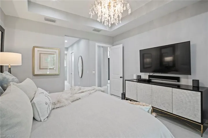Bedroom featuring a chandelier and a tray ceiling