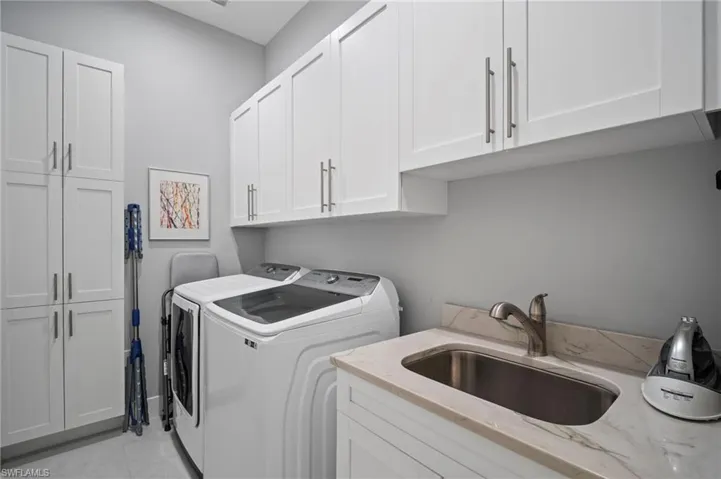 Laundry room with cabinet space, separate washer and dryer, and light tile patterned floors
