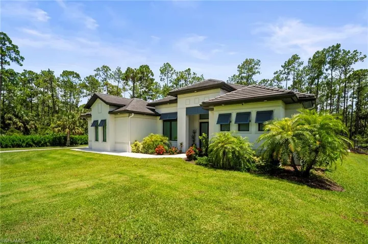Prairie-style house with a tiled roof, a front yard, and stucco siding