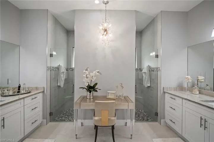 Bathroom with a chandelier, a stall shower, vanity, and tile patterned flooring
