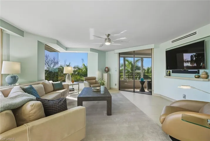 Living area featuring a ceiling fan and baseboards
