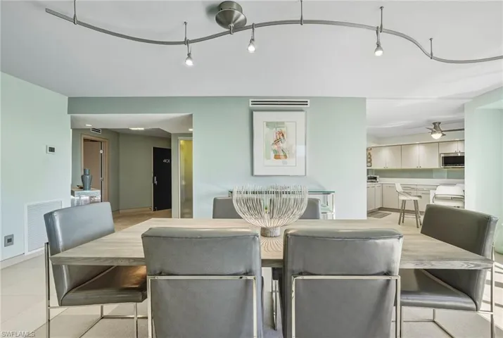 Dining area featuring ceiling fan, light tile patterned floors, and rail lighting