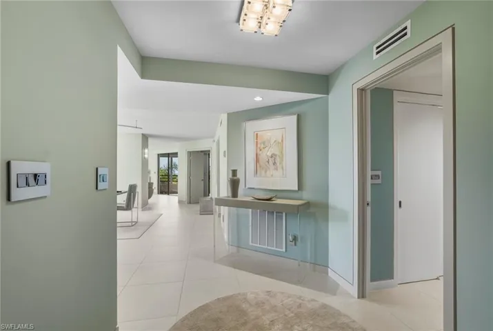 Corridor with light tile patterned floors and recessed lighting