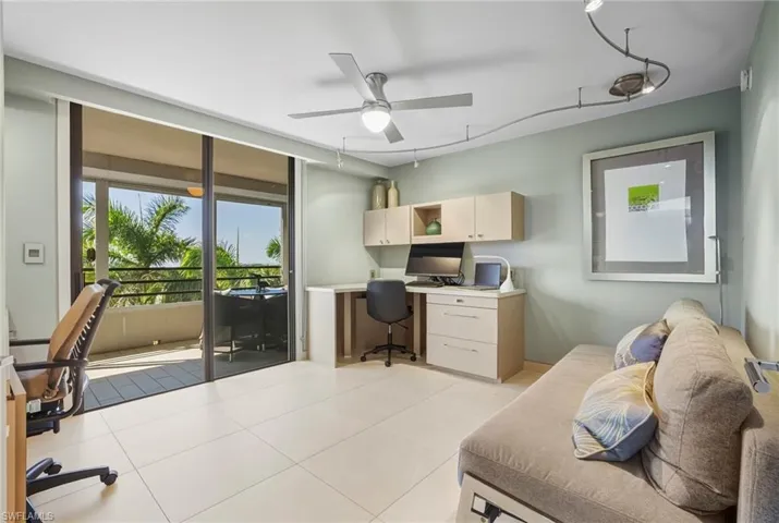 Home office with a ceiling fan, built in desk, and light tile patterned floors