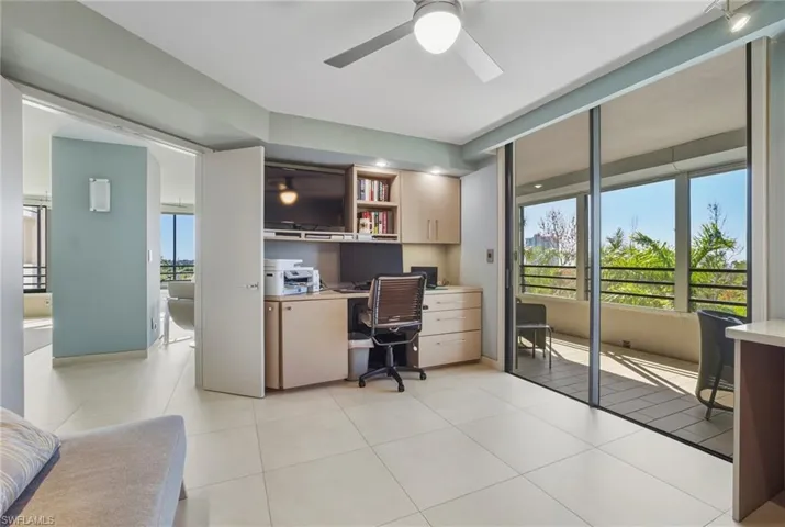 Office featuring built in desk, ceiling fan, and light tile patterned floors