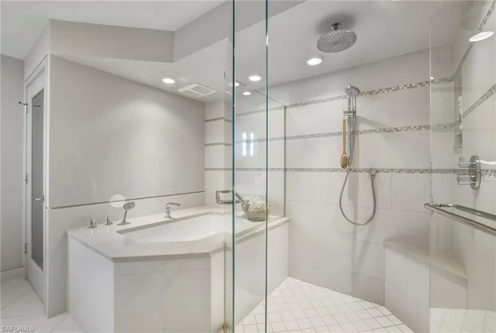 Bathroom with a stall shower, a bath, recessed lighting, and light tile patterned flooring