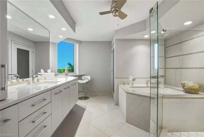 Bathroom with a bath, a stall shower, vanity, recessed lighting, and light tile patterned floors