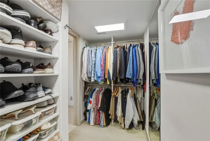 Walk in closet featuring light colored carpet