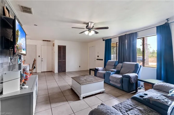 Living area featuring light tile patterned flooring and a ceiling fan