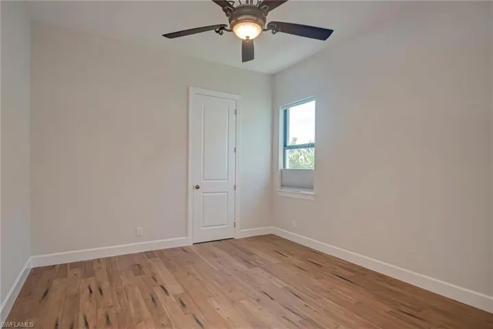 Empty room with light wood-style flooring and ceiling fan