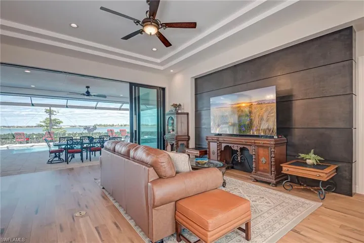 Living area with a sunroom, ceiling fan, light wood finished floors, and recessed lighting