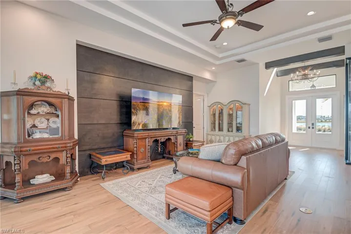 Living room with light wood-style floors, french doors, a chandelier, ceiling fan, and recessed lighting