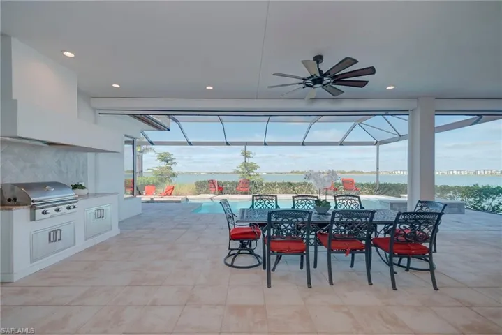 View of patio / terrace featuring ceiling fan, an outdoor pool, area for grilling, outdoor dining space, and a sunroom