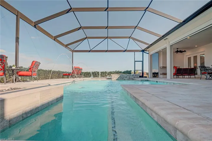 Swimming pool featuring a sunroom, a lanai, a patio area, and french doors