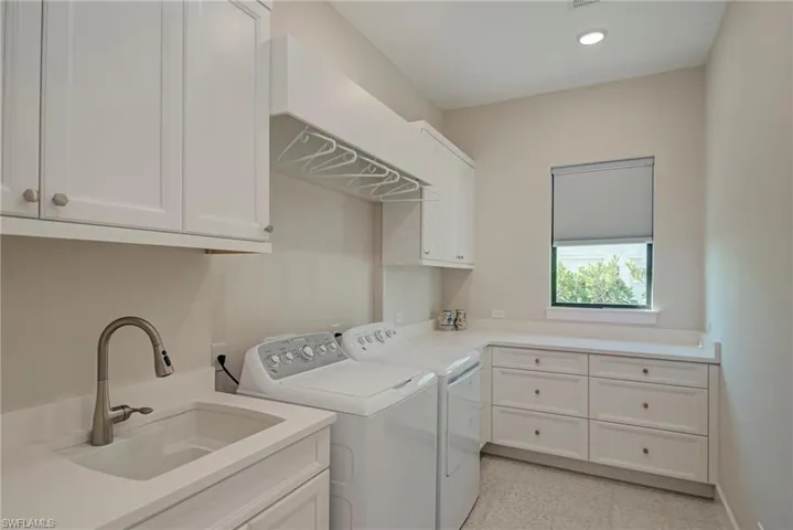 Laundry room with washer and clothes dryer, cabinet space, and recessed lighting