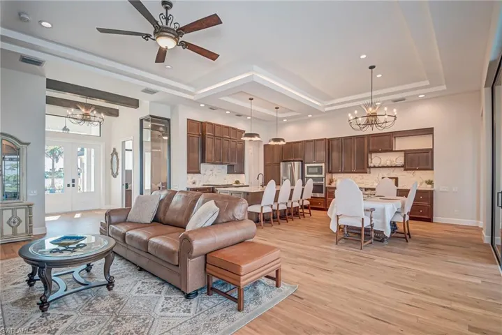 Living area with a chandelier, light wood-style flooring, a ceiling fan, french doors, and recessed lighting