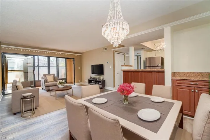 Virtually staged for decorating ideas - Dining area with built in dry bar view towards living room, kitchen and screened in lanai
