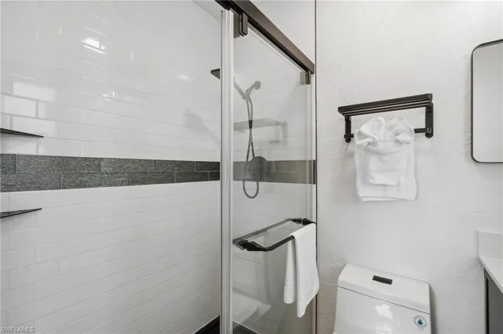 Bathroom featuring vanity, toilet, and an enclosed shower