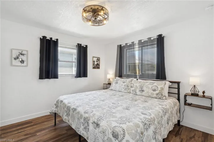 Bedroom with dark hardwood / wood-style floors and a textured ceiling